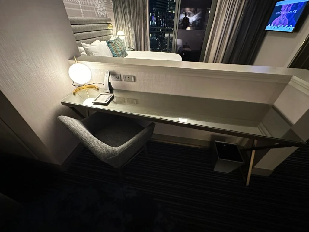 A workdesk in the living area, pushed up against the partition separating it from the bedroom. 