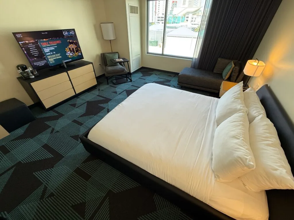 A wide angle of the room that shows the king bed pointed at a TV. 