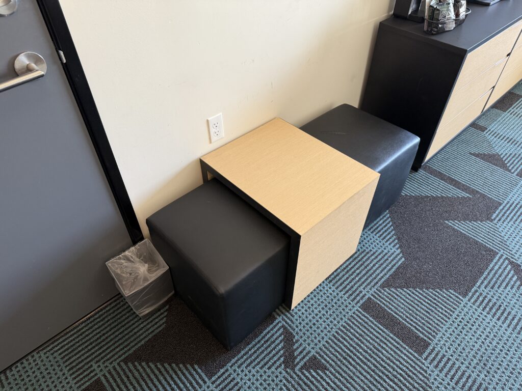 A faux leather bench, with a nexted table placed above it.