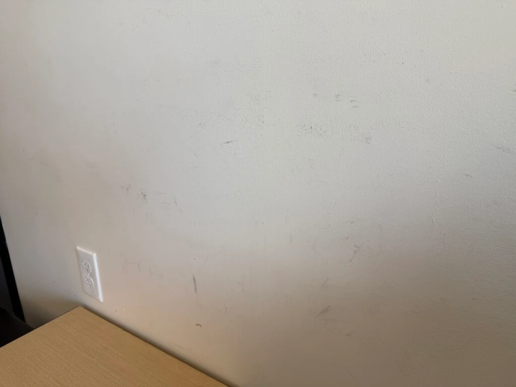 dark scuff marks above the bench on the wall. 