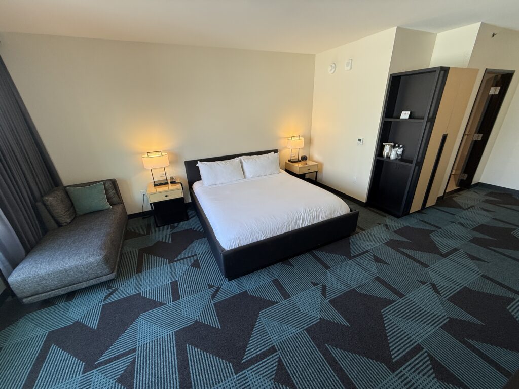 A wide angle shot of the bed area, which demonstrates how much plain wall space there is.