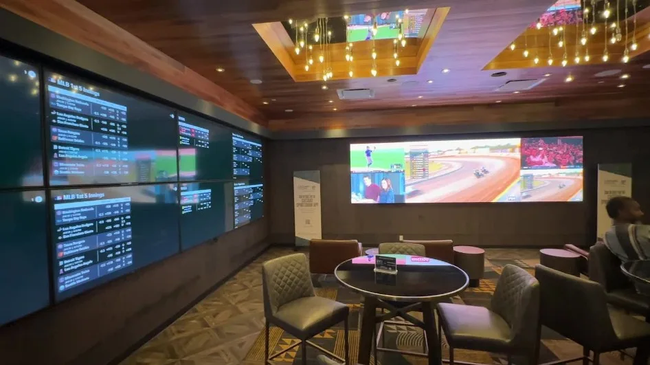 A small sportsbook, with a video wall and odds posted on another. Seating is limited. 