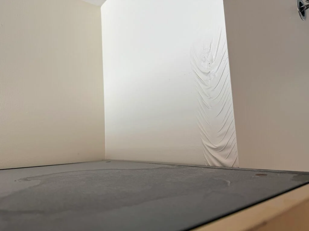 A sagging section of paint above the closet. 