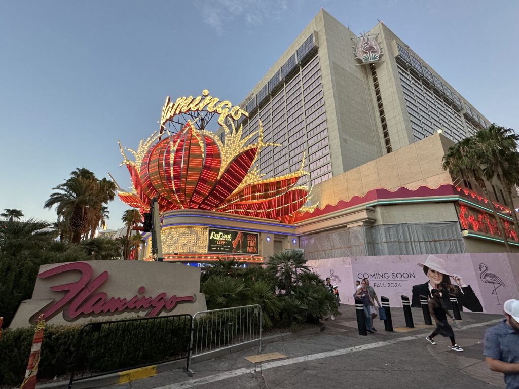 Exterior of Flamingo, with the neon red feather poof above the entryway the focal point.