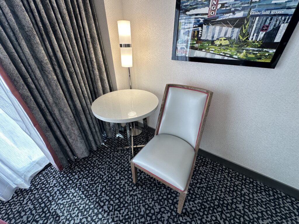 A chair and small round table tucked in the corner.