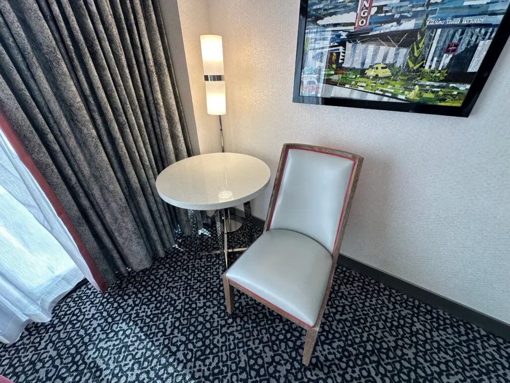 A chair and small round table tucked in the corner. 