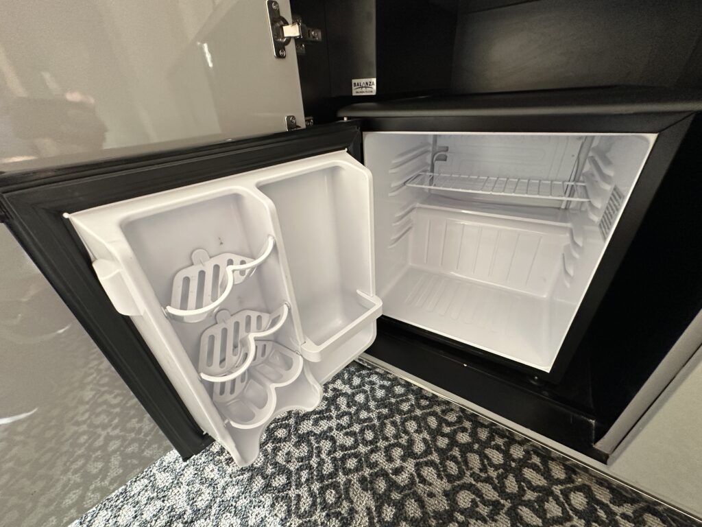 An empty mini-fridge wit the door open.