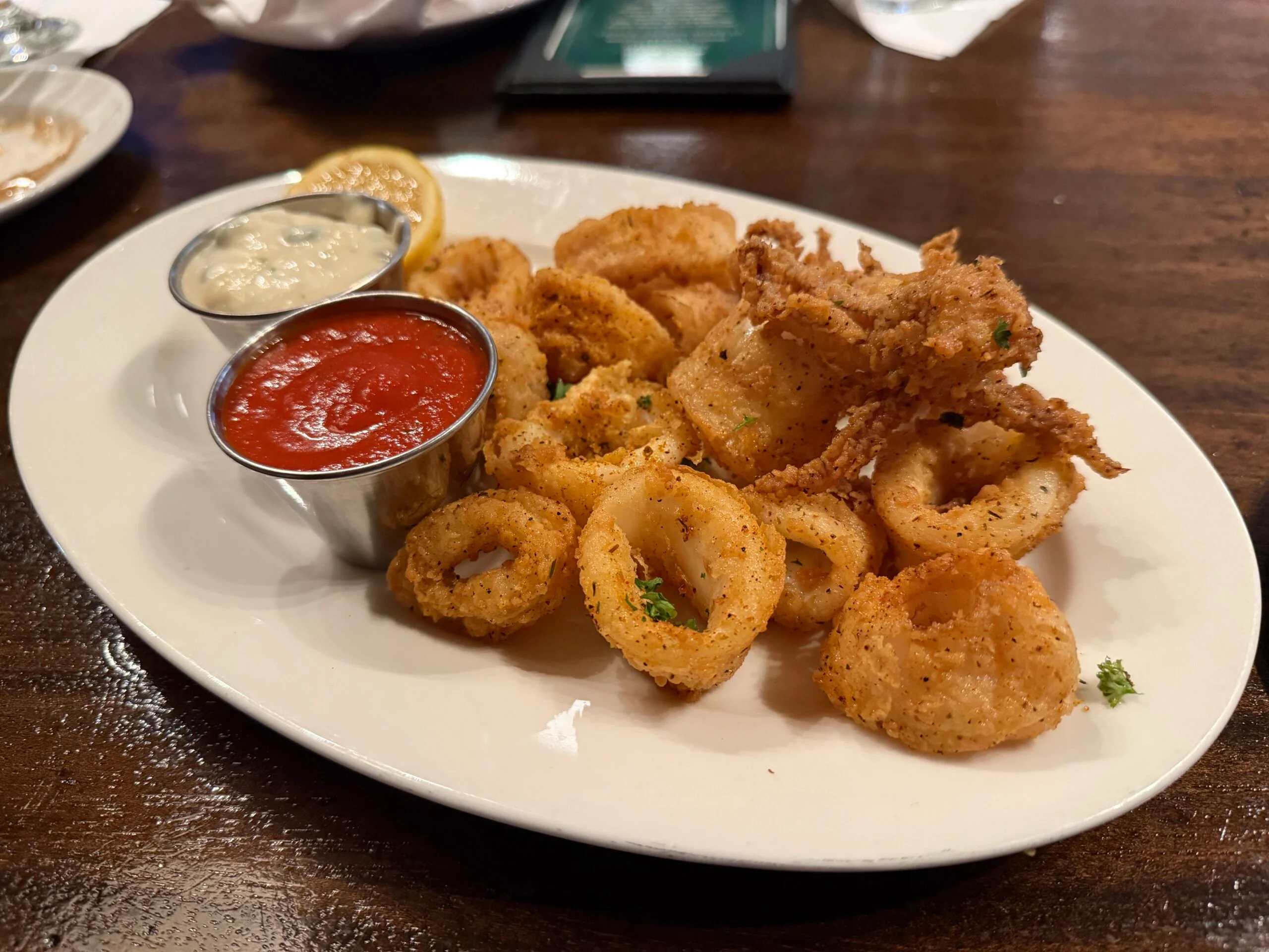 A plate of fried calamari rings on a white plate. 