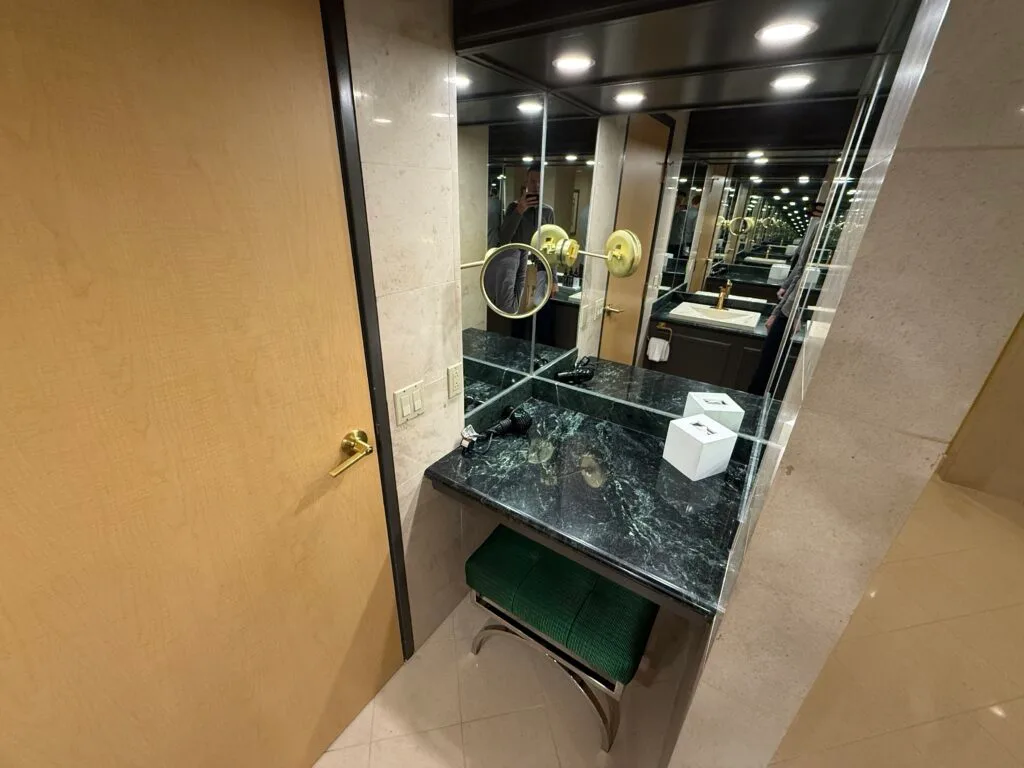 A separate powder station with a pull out stool, green countertops, and plenty of mirrors. 