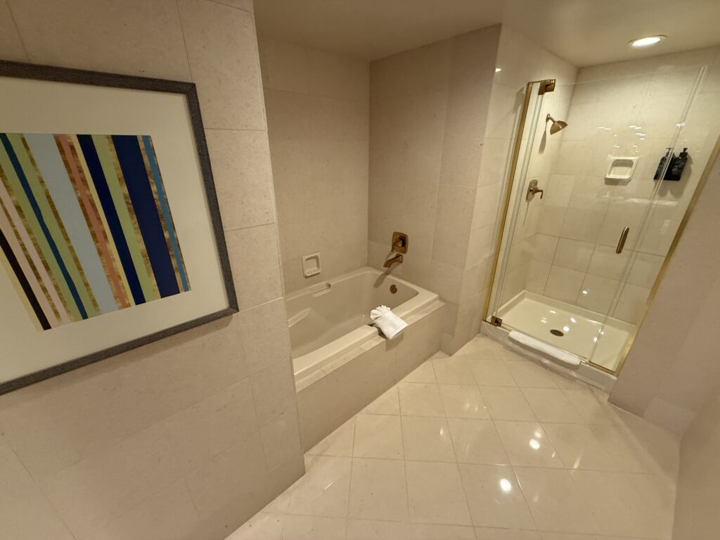 A separate bathtub sitting next to a glass-encosed shower.