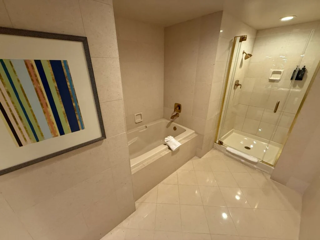 A separate bathtub sitting next to a glass-encosed shower. 