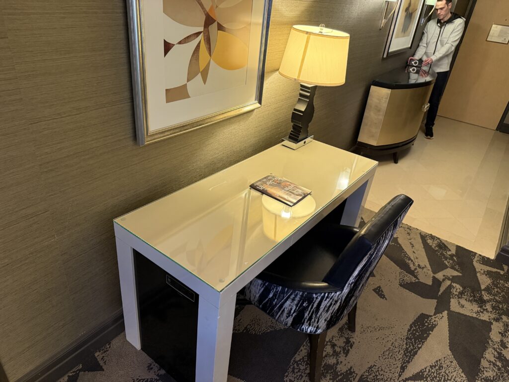 A workdesk and chair, with a bank of plugs on the side.