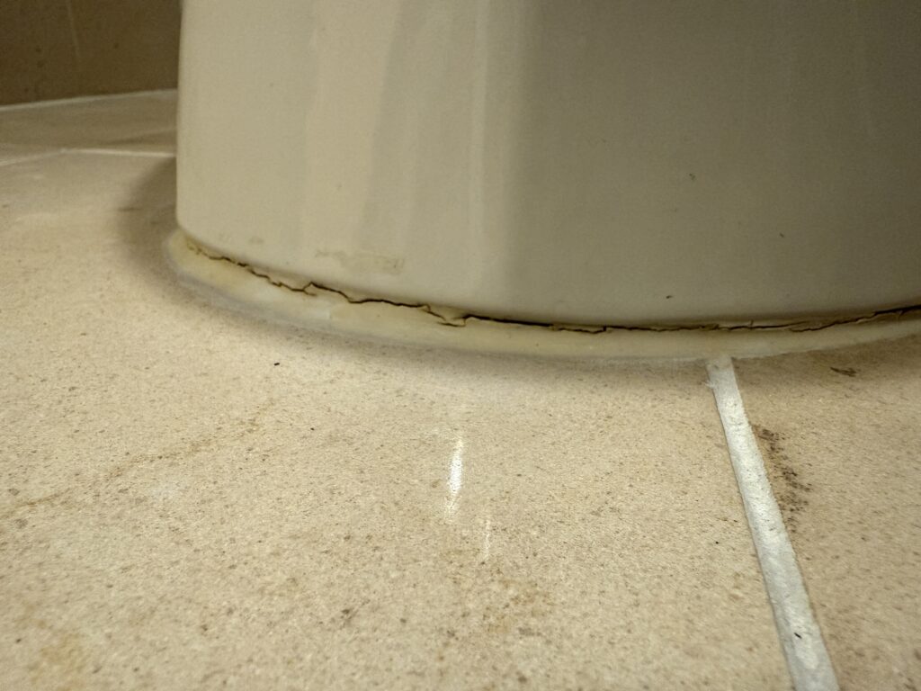Deteriorating Caulk around the base of the toilet.