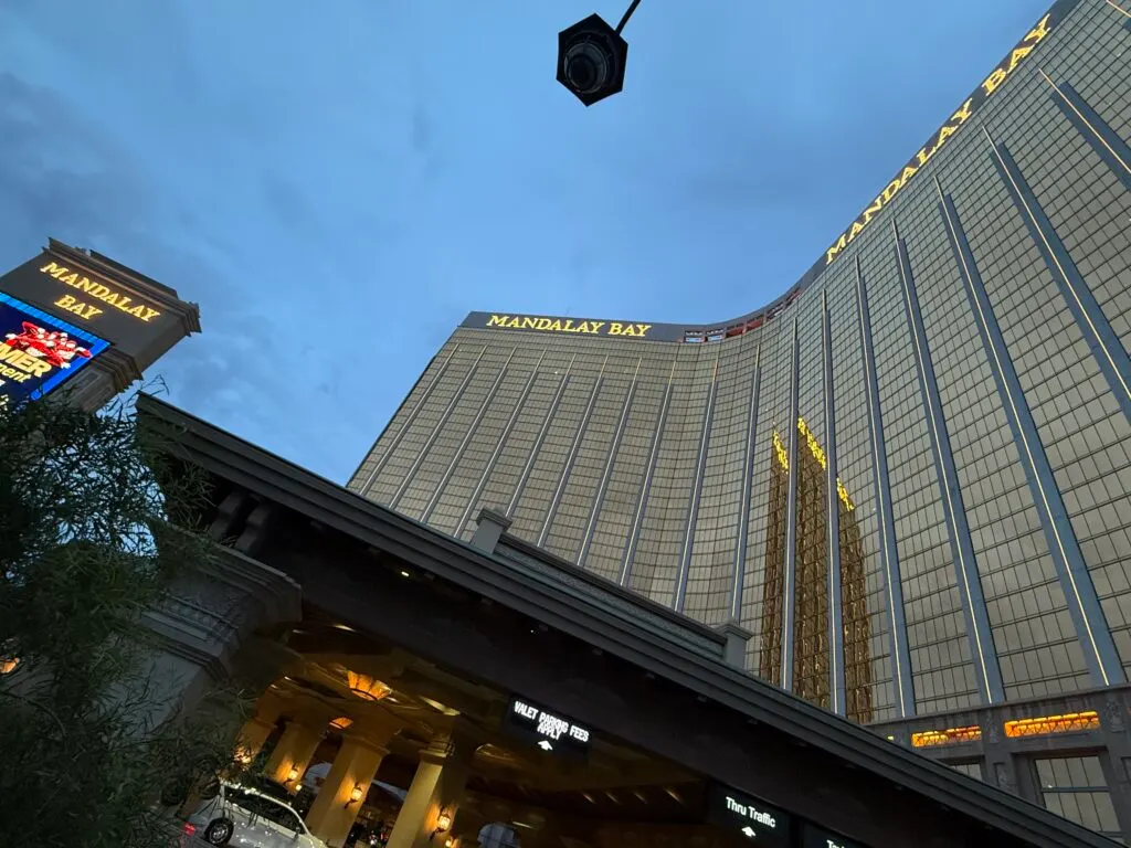 Mandlay Bay's hotel tower from below, illuminated at dusk.