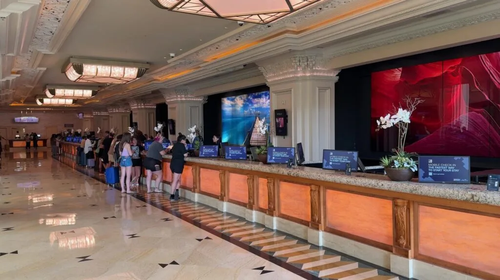 The hotel front desk, with decorative chandeliers overhead.