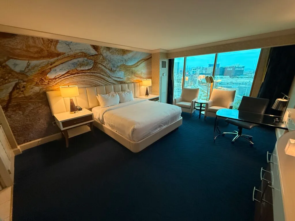 A king bed in front of a decorative accent wall.