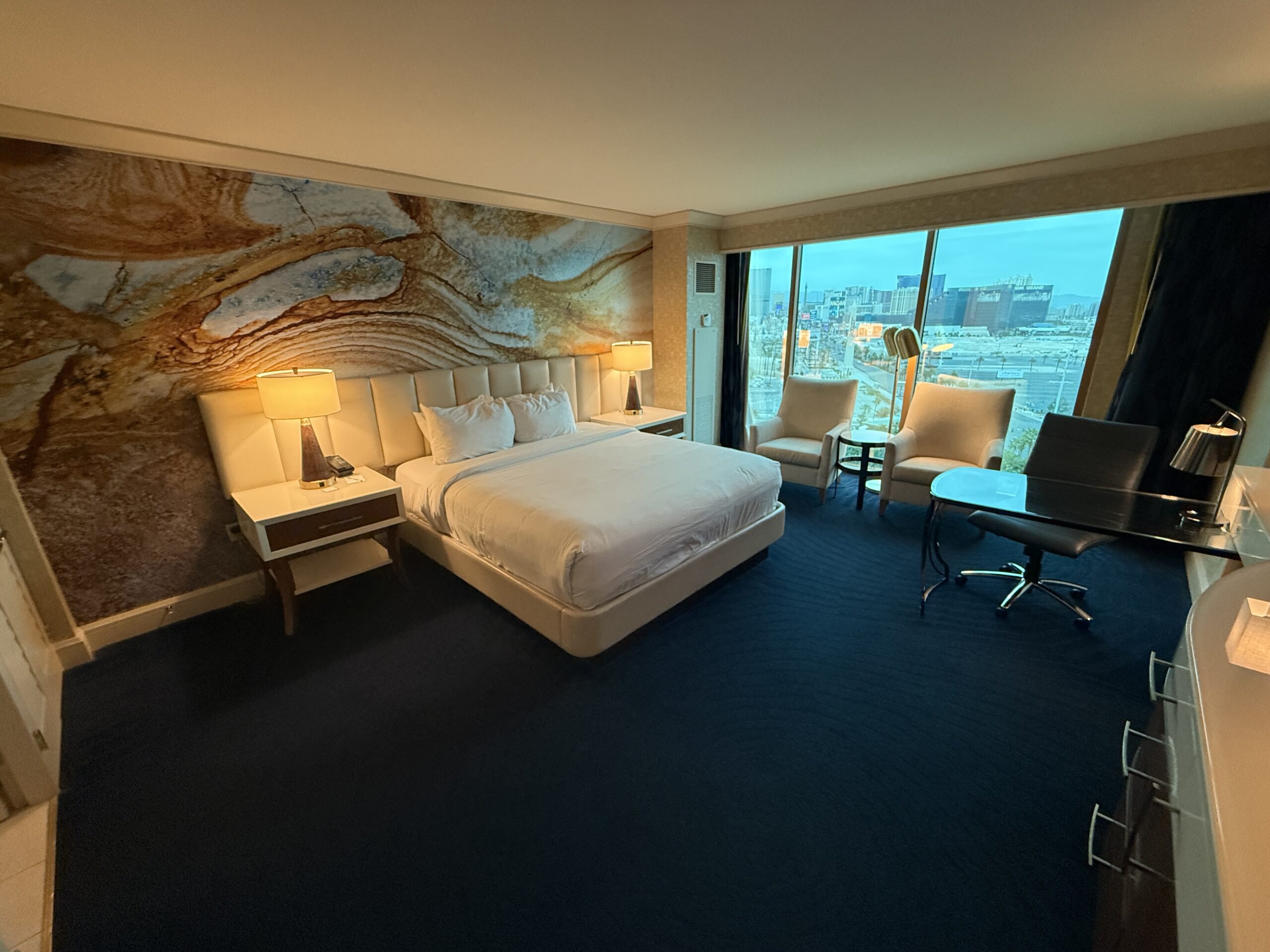 A king bed in front of a decorative accent wall.
