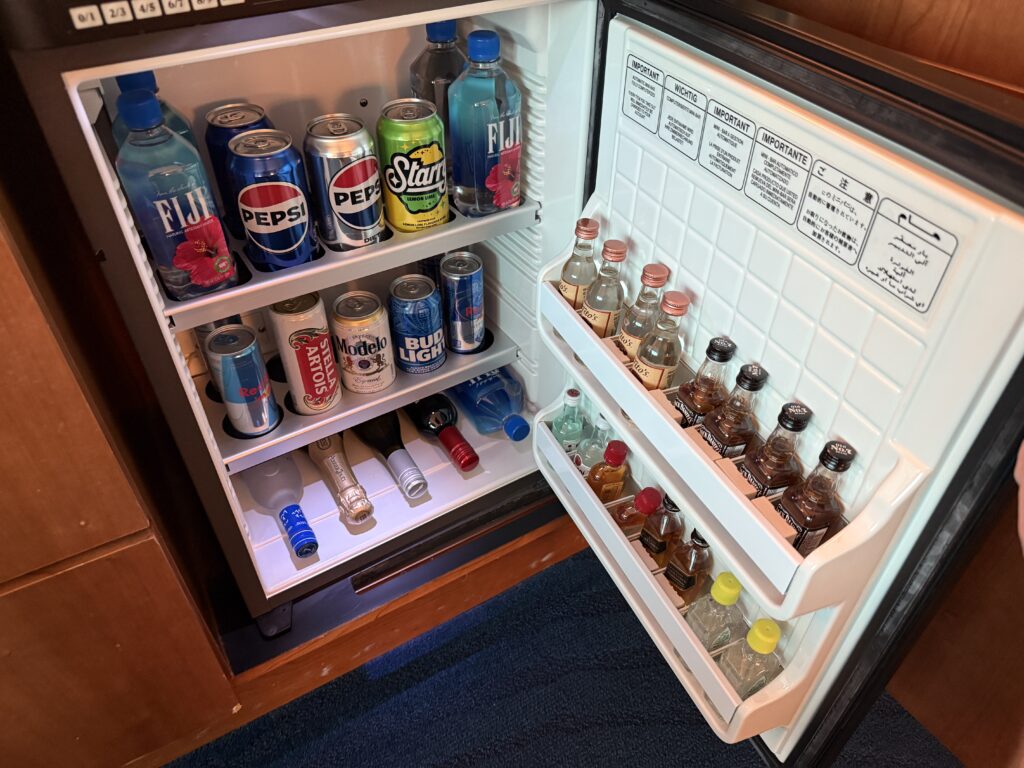 an open mini-fridge stocked iwth beverages for purchase.
