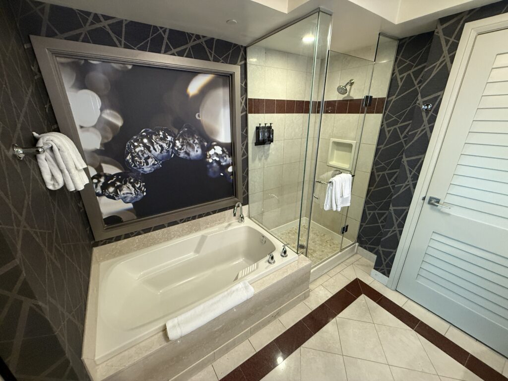 A tub next to a glass enclosed shower.