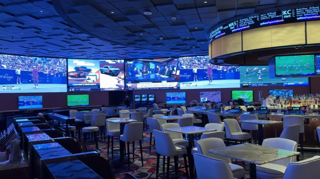 A massive screen playing sports, with a bar to the right. 