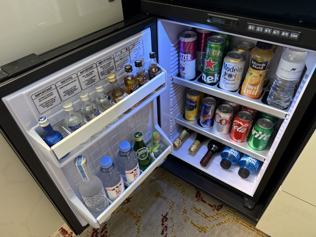 Minibar fridge stocked with beverages.