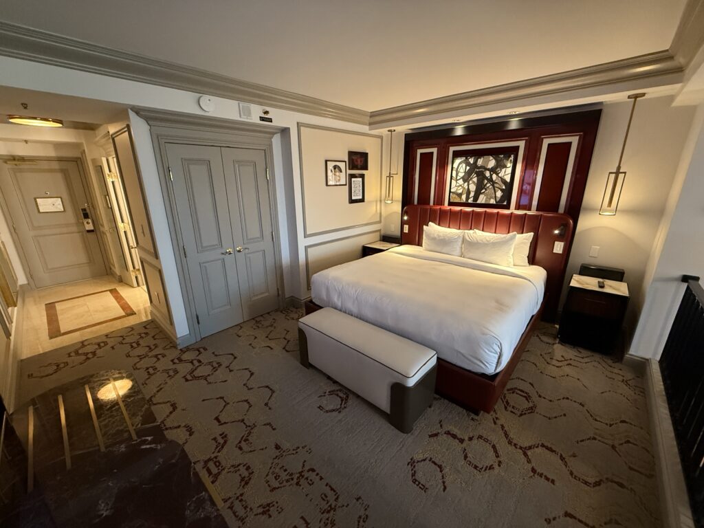 Another angle of the bedroom area showing the hallway leading into the room, the king bed, and the closet.