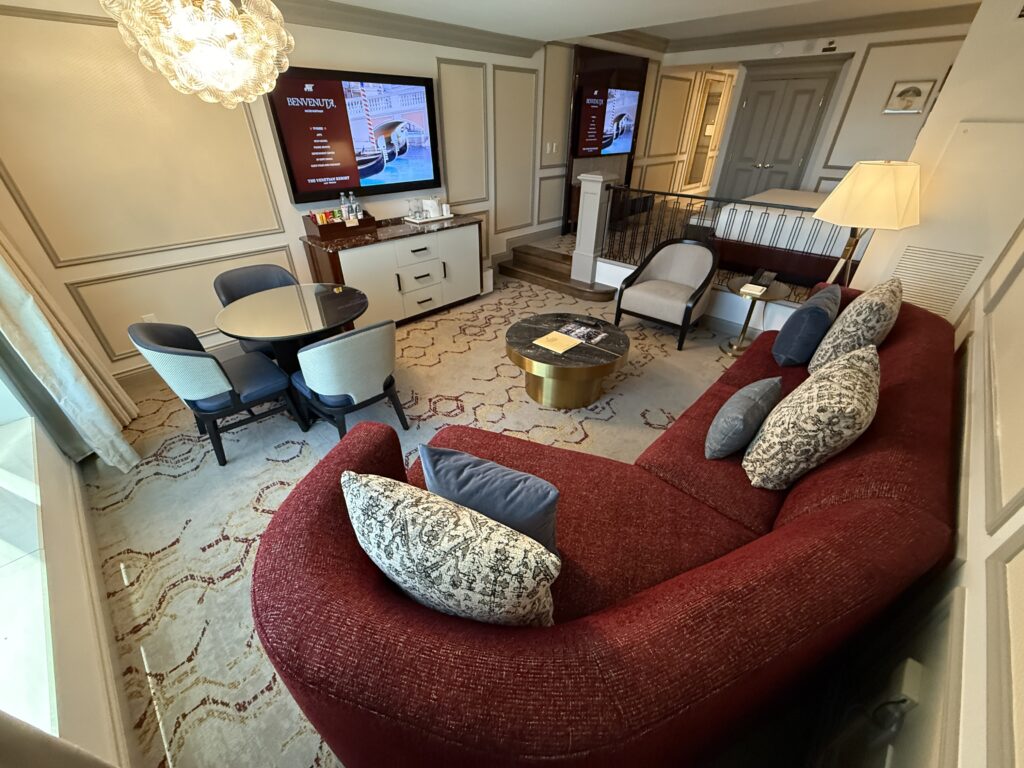 Another angle of the living area that shows the red couch pointing at the TV.