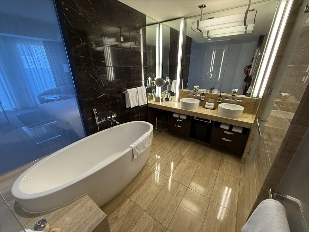 A dual sink vanity, with a stand alone bath tub in the foreground.