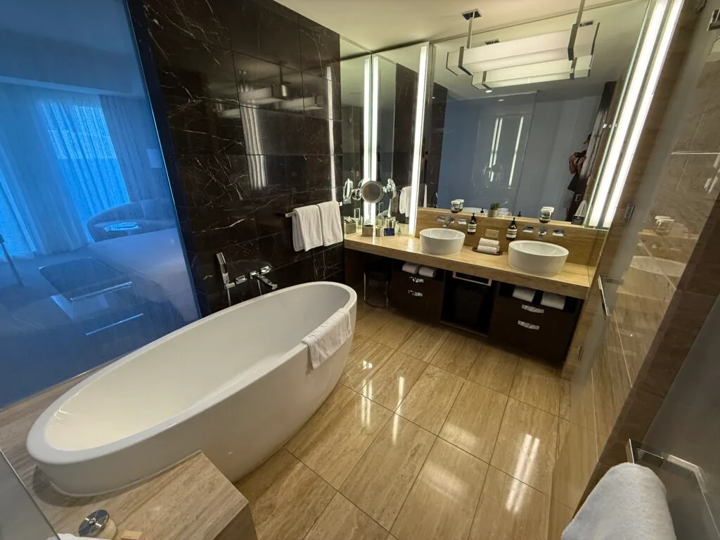 A dual sink vanity, with a stand alone bath tub in the foreground. 