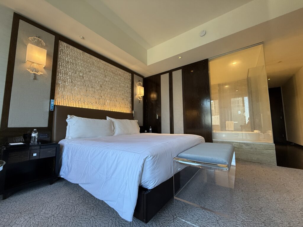 A closer shot of the bed,that shows a bench at the end.