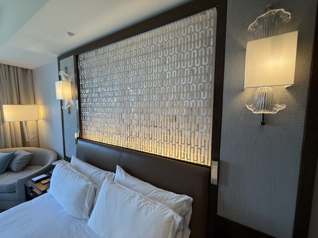 Backlit pattern made of metal above the headboard.