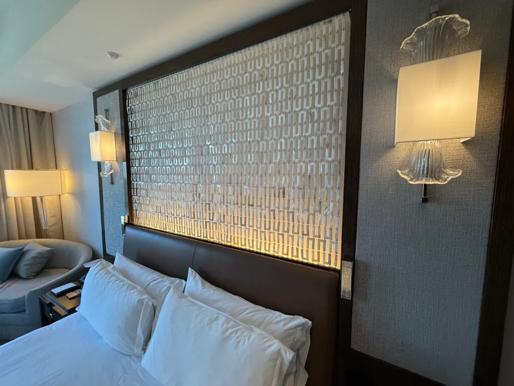Backlit pattern made of metal above the headboard. 