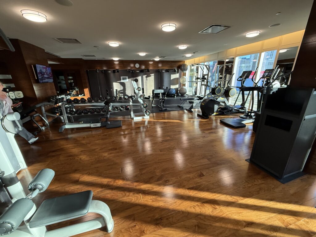Rows of exersize machines in a room.