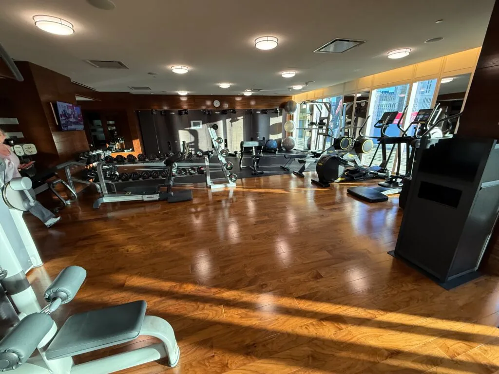 Rows of exersize machines in a room. 