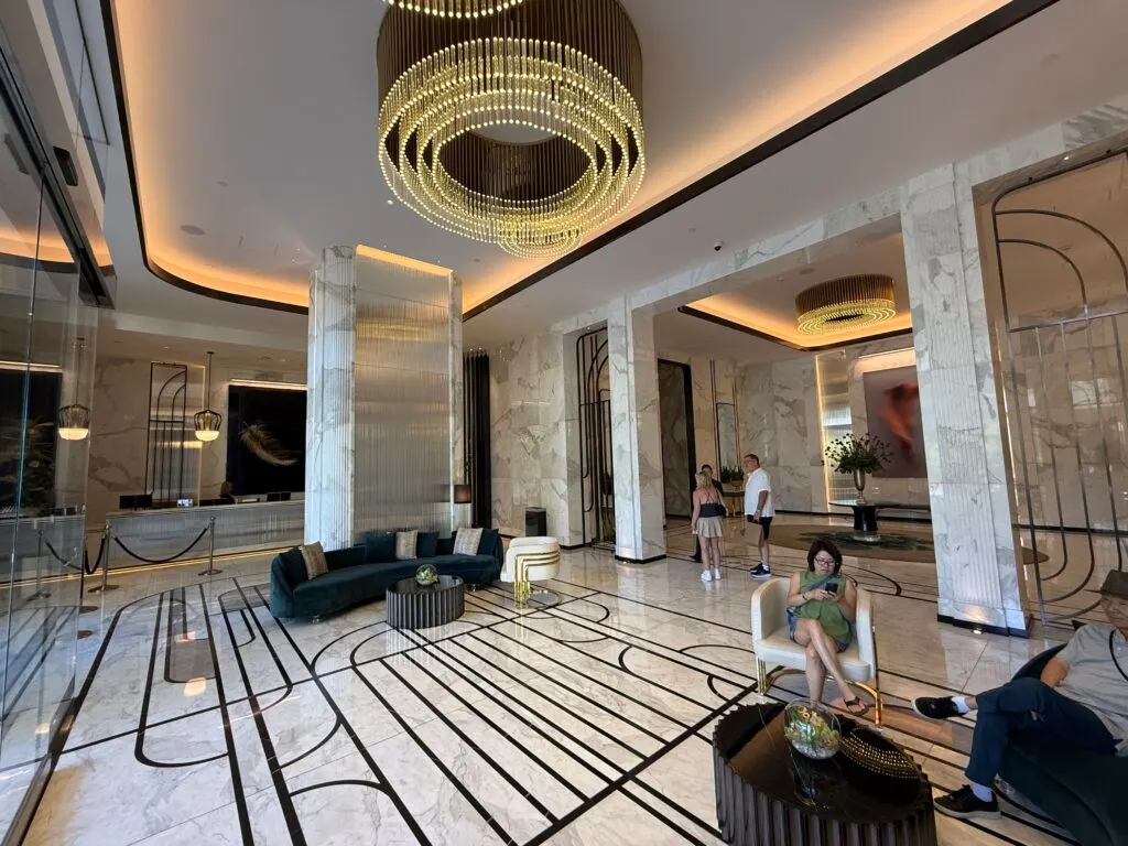 Waldorf's hotel lobby, which has decorative lighting above, stone finishes, and seating. 