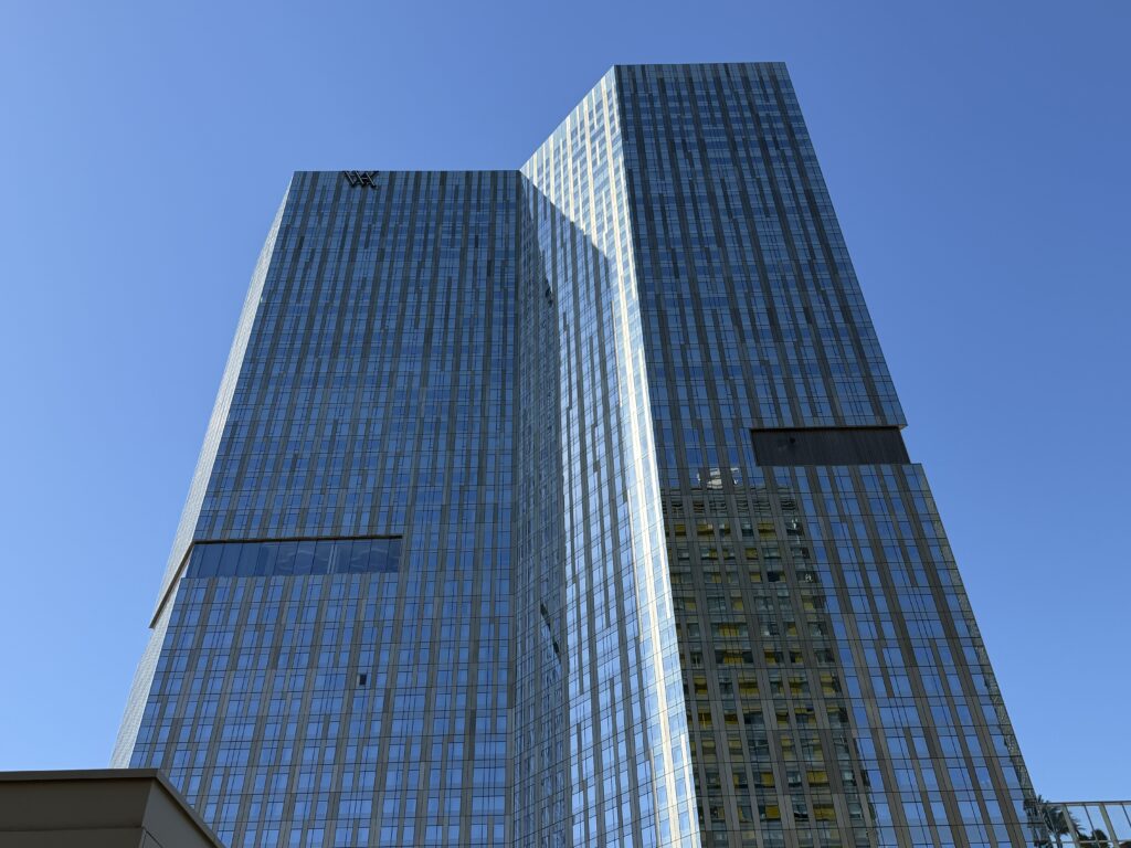 Waldorf Astoria's hotel tower from a distance with a blue sky in the background.