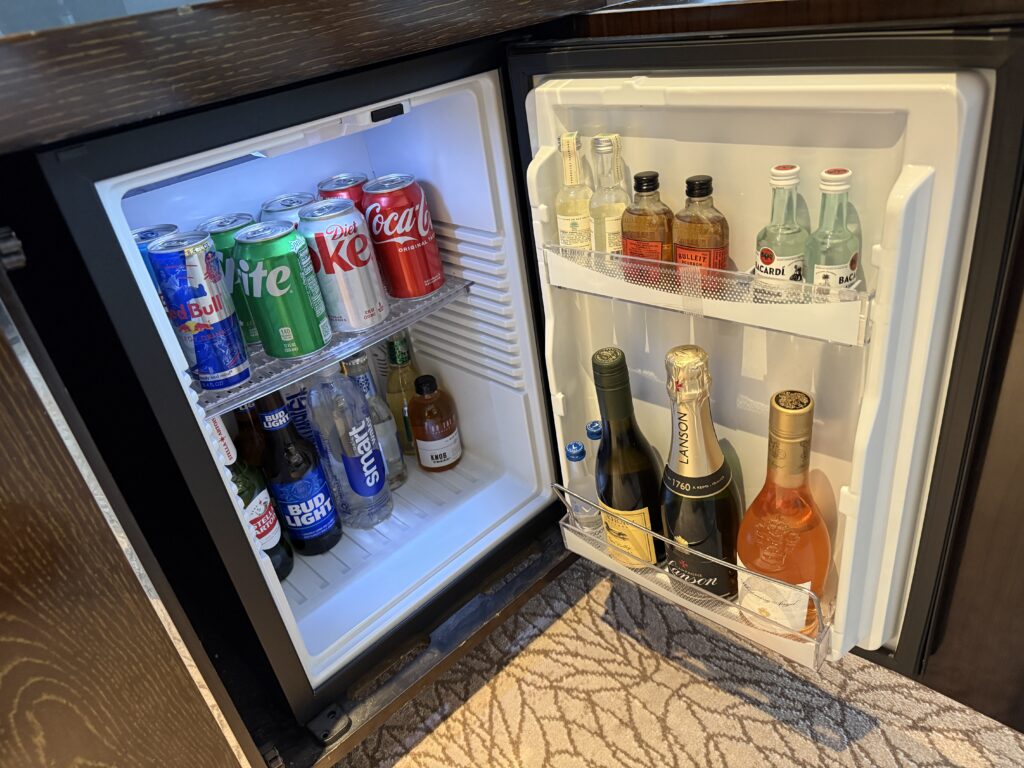 A small fridge stocked with minibar drinks .