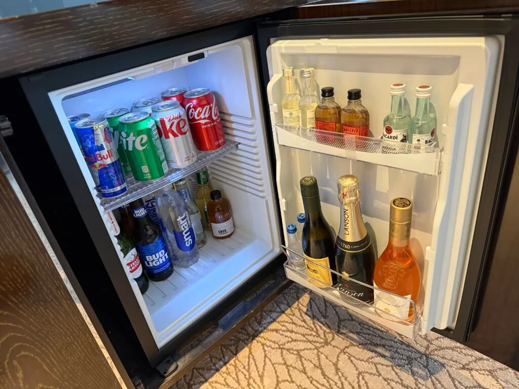 A small fridge stocked with minibar drinks .