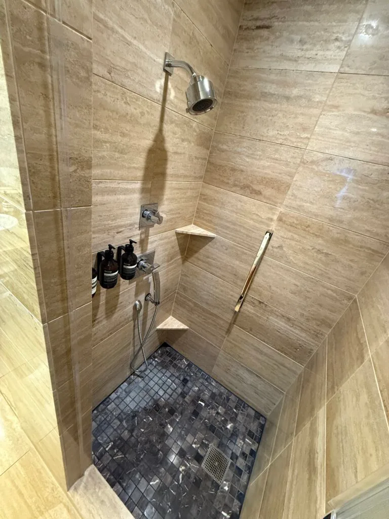 The shower, whichc has complimentary bath products mounted on the wall. 