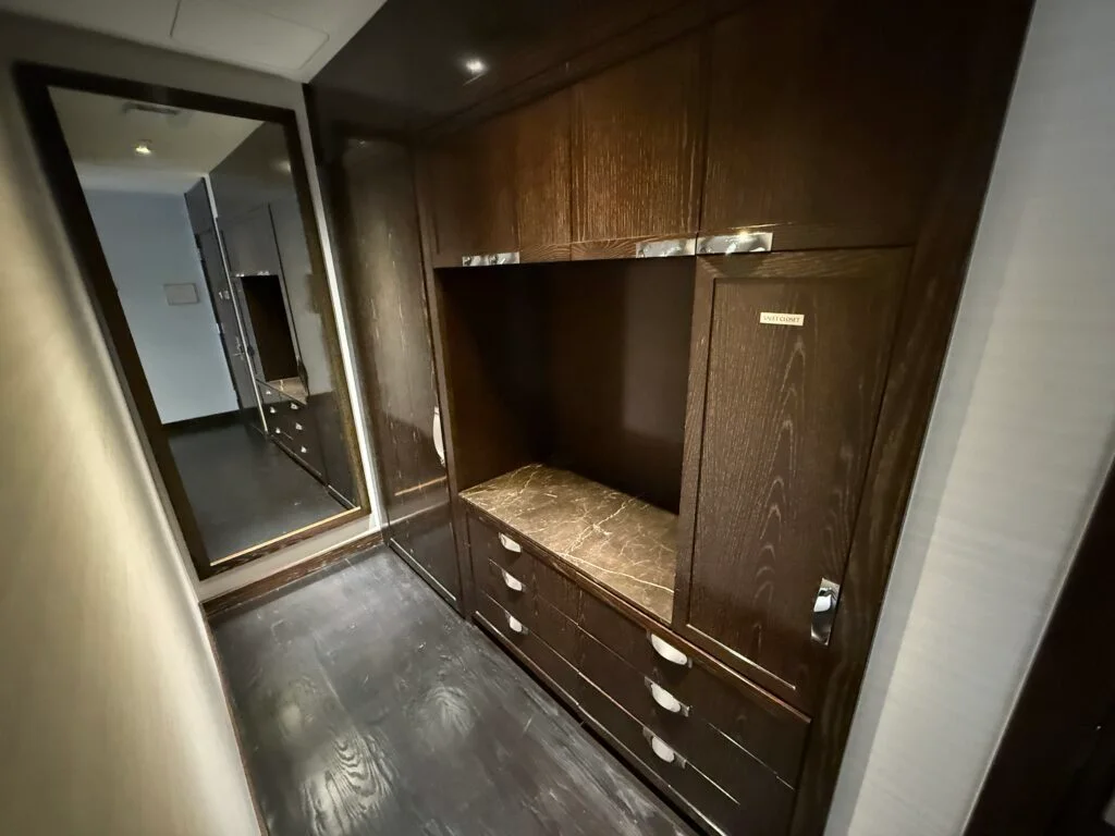 Storage system on the right side of a little hallway. There's also a full length mirror at the end of that hallway. 