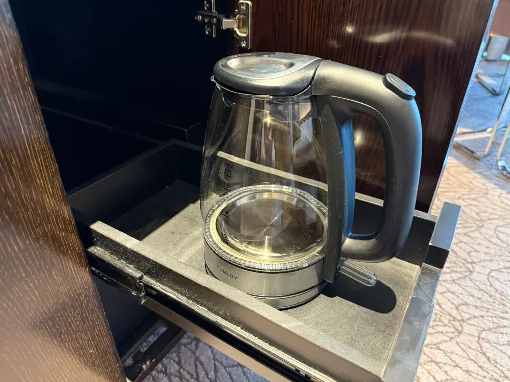 A glass tea kettle in a drawer. 