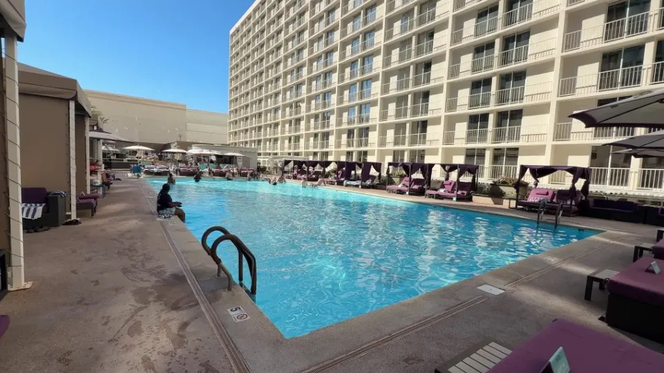 A rectangular pool with the hotel tower in the background. 
