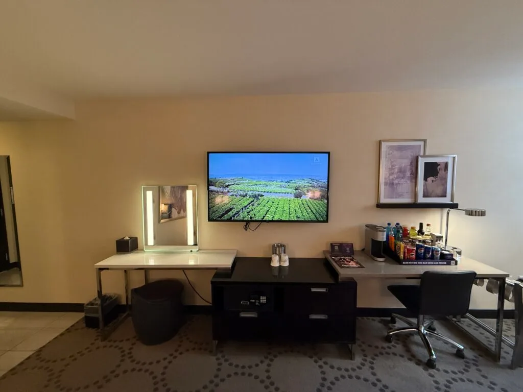 A shot of the TV and the TV stand, mini bar, and work desk below. 