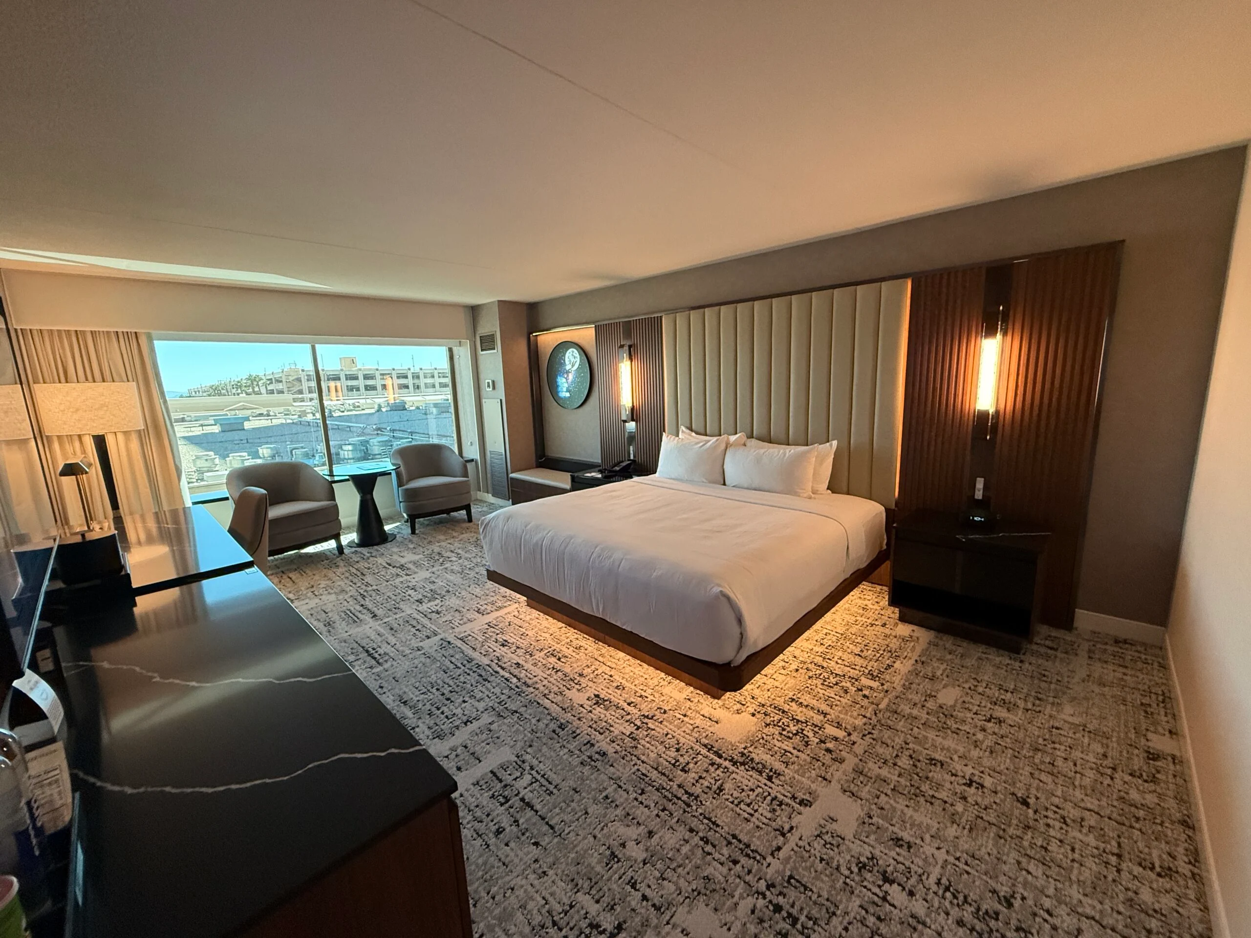 A wide angle shot of the Grand King Room with a king bed with under bed light features. 