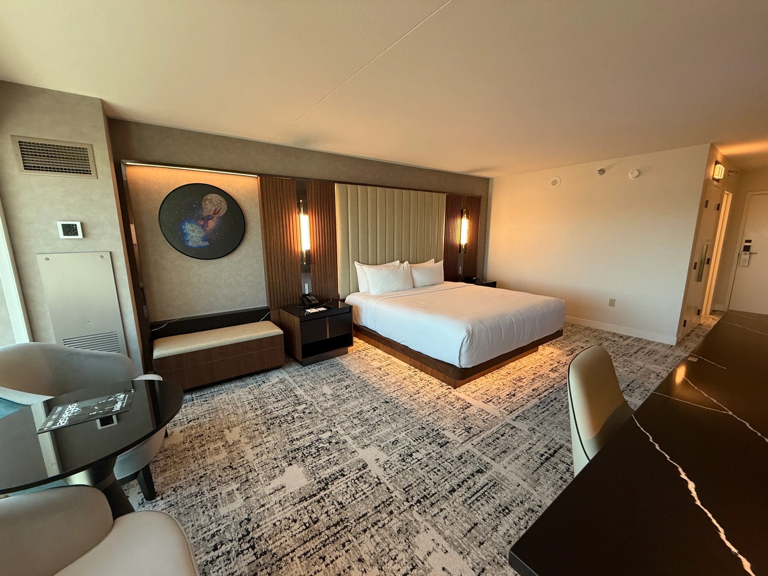 Another angle of the king bed, this one shows a bench to the left of the bed. 