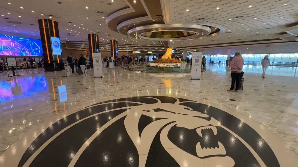 MGM Grand's Hotel lobby with a lion emblazoned on the floor in the foreground, and a golden lion statue in the distance. 