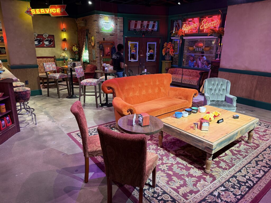Another angle of Central Perk, that shows the couch, table, and exterior window & door in the background. 