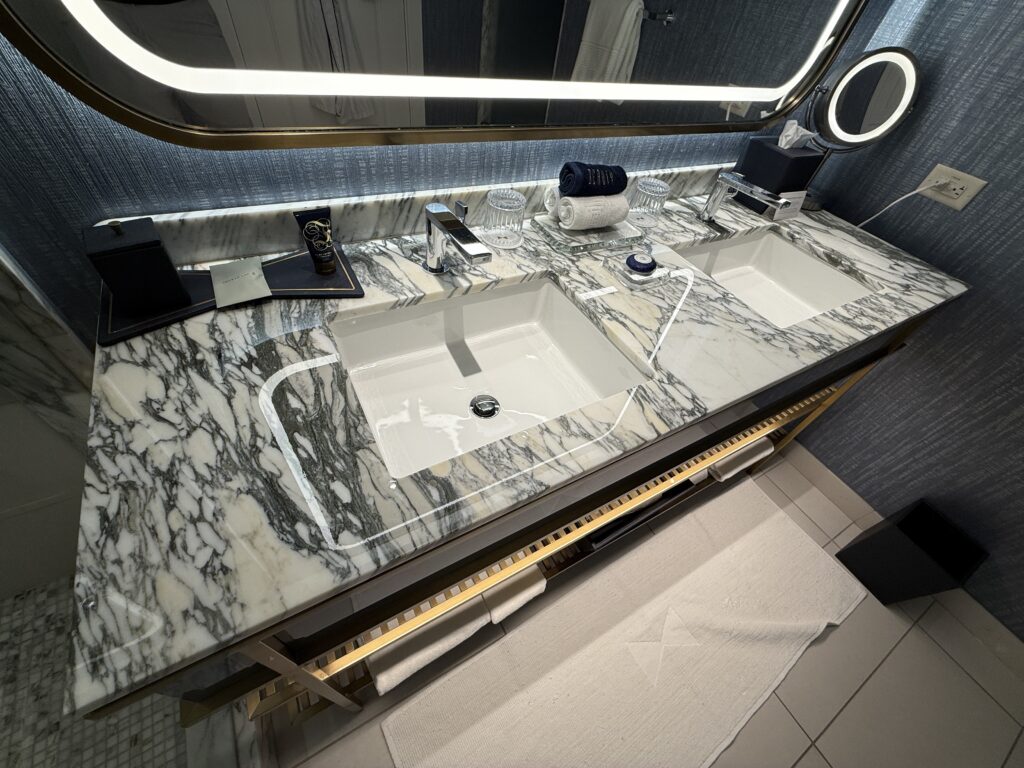 A dual sink vanity with a dark and white marble countertop. 