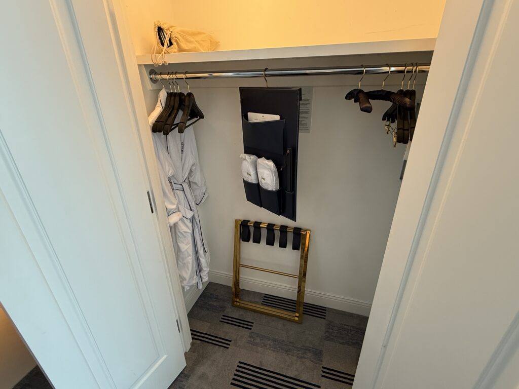 A closet stocked with robes and 2 sets of slippers. 