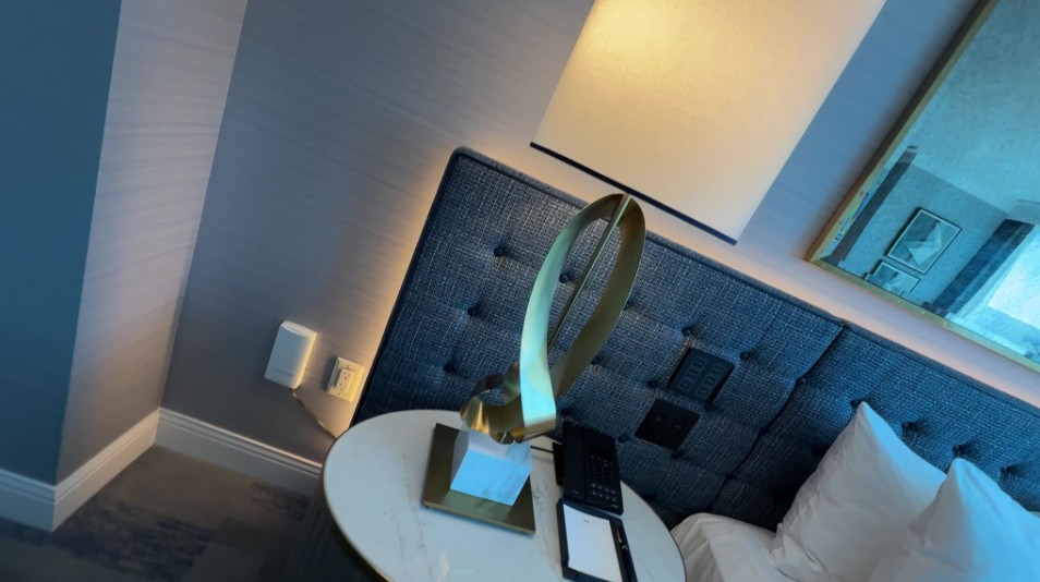 A close look at the corner of the padded headboard, with soft light coming out from behind it.